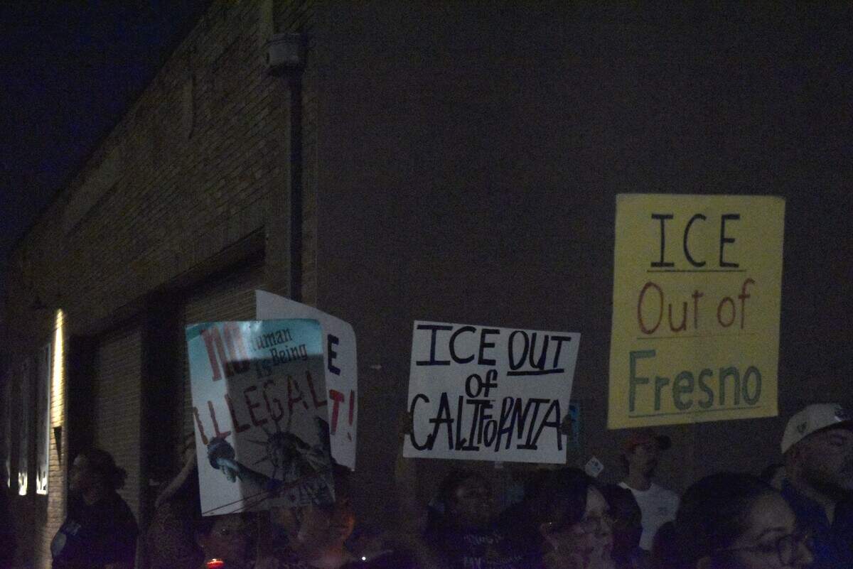 Community members hold signs in protest of ICE outside the federal agency’s facility in downtown Fresno on the night of Thursday, Oct. 8, 2026.